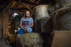 Auf dem Dachstock lagert die Familie Achermann die Heuballen. Bild: Corinne Glanzmann (Flühli, 08. August 2018)