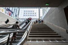 Die Rolltreppe aus der Rathausunterführung in die neue Ankunftshalle des Bahnhofs St.Gallen. Erkennbar ist die als «Kunst am Bau»-Projekt entstandene binäre Uhr und - links im Bild - die verlegte Businformationstafel, die in den vergangenen Wochen ziemlichen Wirbel ausgelöst hatte. (Bild: Hanspeter Schiess - 29. August 2018)