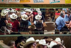 Die Spiegel an der Wand verdoppeln die ohnehin zahlreichen Cowboy-Hüte.