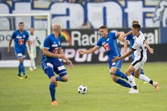 Luzerns Filip Ugrinic (Mitte) im Zweikampf mit Luganos Eris Abedini. (Bild: Pius Amrein (Luzern, 4. August 2018))