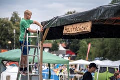 Sven von den "Heutröchner" befestigt die Plane des Pavillons.