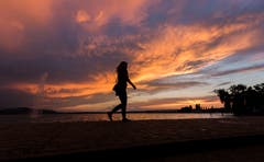 Eine Frau spaziert am Zugersee entlang. (Bild: Daniel Hegglin (Zug, 7.August 2018))