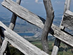 Viel schöner als ein kalter, stachliger Maschendrahtzaun ist so eine gelungene Konstruktion "Naturholzzaun". Küssnacht am Rigi liegt uns zu Füssen und wir haben den nötigen Durchblick, den wir geniessen. (Bild: Margrith Imhof-Röthlin (Rigi, 8. August 2018))