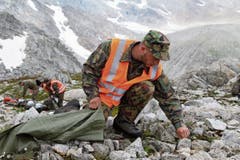 Im Einsatzgebiet «unter den Hüenerstöcken» sammelt ein Soldat Munitionsreste ein. (Bild: Philipp Zurfluh, Realp, 9. August 2018)