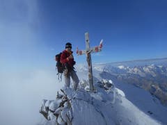 Auf dem Gipfel vom Dom 4545m. Links vom Gipfelkreuz ist teilweise die Monte-Rosa Gruppe zu sehen. Rechts vom Gipfelkreuz sind folgende Berge zu sehen: Lyskamm, Castor, Pollux Breithorn und das Matterhorn. (Bild: Raphael Wellig (Wallis, 8. September 2018))