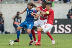 Die Schweizer Denis Zakaria (Mitte) und Granit Xhaka (rechts) kämpfen gegen Isalnds Birkir Bjarnason um den Ball. (Keystone/Peter Schneider (St. Gallen, 8. September 2018))