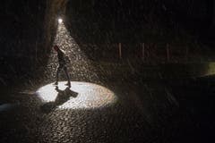 Ein Scheinwerfer und Schneefall bringen Licht ins Dunkel. (Bild: Urs Flüeler / Keystone (Luzern, 9. Januar 2019))