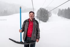 Er nimmt für die Fotografin einen Bügel in die Hand ....