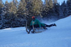 Eine Variante, wie man den Hornschlitten lenken kann: Die hintere Person steuert mit den Füssen. Im Bild: Julius und Sandra Aregger. (Bild: Kurt Stadelmatt (19. Januar 2019))