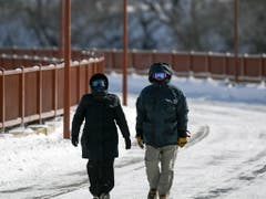 Gut «verpackte» Spaziergänger in Minneapolis: Einige Bundesstaaten haben wegen der Kälte den Katastrophenfall ausgerufen. (Bild: KEYSTONE/EPA/CRAIG LASSIG)