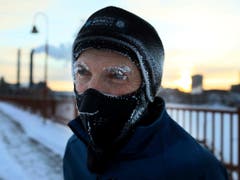 Der US-Wetterdienst warnt vor tiefen Atemzügen in der Kälte. Ein Einwohner in Minneapolis schützt sich mit einem Mundschutz. (Bild: KEYSTONE/AP Star Tribune/DAVID JOLES)