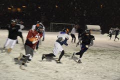 Neben Passspielzügen hat der Quarterback (rotes Trikot) auch die Möglichkeit, den Ball seinem Running Back zu übergeben, der versucht möglichst weit nach vorne zu laufen. Der Quarterback kann den Ball aber auch selbst nach vorne tragen.