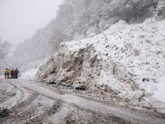 Einsatzkräfte räumen nach einer Lawine eine Strasse frei. Bild: Bernd März / DPA
