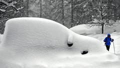 Ein eingeschneites Auto in der Ramsau am Dachstein in Österreich. Bild: Harald Schneider / APA)