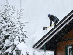 Ein Mann befreit ein Dach von der Schneelast am Mittwoch in der Nähe von Untertauern in Österreich. (Bild: Keystone/APA/APA/HELMUT FOHRINGER)