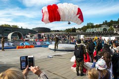 Zuschauer beobachten den Absprung der Fallschirmspringer mit anschliessender Landung in der Arena im Verkehrshaus. (Bild: Dominik Wunderli, Luzern, 12. Oktober 2019)