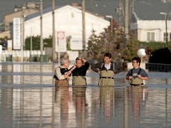 In Nagano stehen Angestellte einer Firma im Hochwasser, um den Zustand ihres Büros (nicht im Bild) zu prüfen. Die Provinz Nagano war am stärksten von Überschwemmungen betroffen, nachdem der Chikuma-Fluss durch die Uferdämme gebrochen war. (Bild: KEYSTONE/EPA/KIMIMASA MAYAMA)