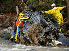 Rettungskräfte bergen nach dem Taifun «Hagibis» ein Autowrack aus einem Fluss bei Koriyama in der Nähe von Fukushima. (Bild: KEYSTONE/AP Kyodo News/KOTA ENDO)