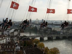 Besucher vergnügen sich auf der «Condor» beim Kasernenareal an der Herbstmesse in Basel, im Hintergrund das Riesenrad beim Münster. (Bild: KEYSTONE/ALEXANDRA WEY)