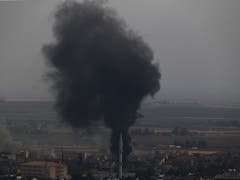 Die kurdische YPG-Miliz leistete am Mittwoch in der nordsyrischen Grenzstadt Ras al-Ain weiter erbitterten Widerstand. Die Kämpfer zündeten Reifen an, um mit dem Rauch den türkischen Kampfjets die Sicht zu erschweren. (Bild: KEYSTONE/AP/LEFTERIS PITARAKIS)