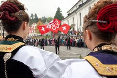 Die drei Fähndriche zeigen auf dem Dorfplatz ihre Künste im Fahnenschwingen. (Bild: Edi Ettlin, Stans, 20. Oktober 2019)