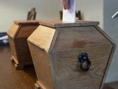 In Guttannen werden die Wahl- und Abstimmungszettel noch in eine Holzurne eingelegt. (Bild: KEYSTONE/PETER SCHNEIDER)