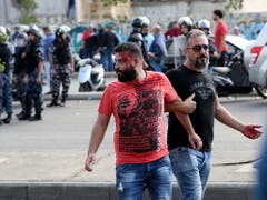 Die Hisbollah greift Protestler an: Ein Verletzter wird in Beirut nach einer Auseinandersetzung weggeführt. (Bild: KEYSTONE/EPA/NABIL MOUNZER)