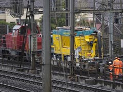 Ein Schienentraktor zieht den Bahnflachwagen mit dem Sauglaster. (Bild: KEYSTONE/PETER KLAUNZER)