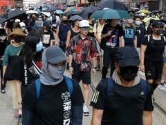 Hunderte meist maskierte Demonstranten haben am Samstag in Hongkong dem neu erlassenen Vermummungsverbot getrotzt. (Bild: KEYSTONE/AP/VINCENT THIAN)