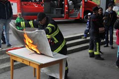 Christian Gisler demonstriert, wie ein Brand einer Bratpfanne mit der Löschdecke bekämpft wird. (Bild: Paul Gwerder, Erstfeld, 5. Oktober 2019)
