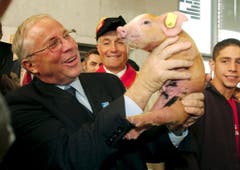 62. Olma: Bundesrat Christoph Blocher hält ein Säuli in die Kameras. (Bild: Keystone/Regina Kühne, 7. Oktober 2004)