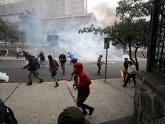 Die Sicherheitskräfte setzten am Dienstag erneut Tränengas ein, um einen Sturm auf das Parlament in Ecuador zu verhindern. (Bild: KEYSTONE/EPA EFE/JOSE JACOME)