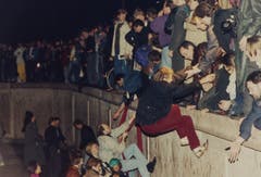 Ostberliner helfen Westberlinern in der Nacht über die Mauer. (Bild: Jockel Finck / Keystone, 9. November 1989)