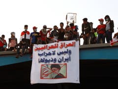 «Irak den Irakern und nicht den iranischen Parteien und ihren Ausläufern» steht auf dem Transparent in Bagdad mit dem Bild des iranischen geistlichen Oberhaupts Ayatollah Ali Chamenei. (Bild: KEYSTONE/EPA/AHMED JALIL)