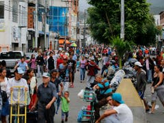 Venezolanerinnen und Venezolaner gehen in San Antonio zu Fuss über die Grenze nach Kolumbien. Einige kaufen im Nachbarland Essen und Medikamente, andere verlassen Venezuela für immer. (Bild: KEYSTONE/AP/FERNANDO LLANO)