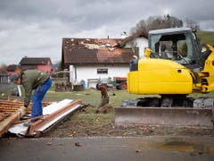 Ein Hausbesitzer zieht Nägel aus seinem abgedeckten Dach. (Bild: KEYSTONE/GIAN EHRENZELLER)
