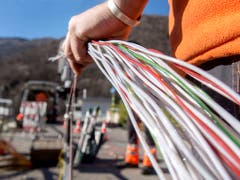 Ein Arbeiter montiert Glasfaserkabel der Swisscom. Die Comcom stützt sich bei der Preisberechnung für die Mitbenützung des Swisscom-Netzes neu auf die Kosten für Glasfaserleitungen. (Bild: KEYSTONE/TI-PRESS/CARLO REGUZZI)