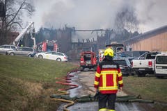 Die Feuerwehr verhindert mit ihrem Löscheinsatz das Übergreifen des Feuers auf umliegende Gebäude. (Bild: Dominik Wunderli)