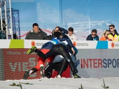 Die Teamkollegen jubeln mit: Killian Peier wird von Simon Ammann und Andreas Schuler umarmt und zu Boden gerissen (Bild: KEYSTONE/EPA/CHRISTIAN BRUNA)