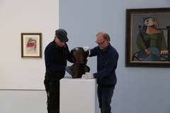 Jeder Griff sitzt: Würth-Mitarbeiter platzieren eine Bronze-Skulptur von Hans Arp. Ein Gemälde von Pablo Picasso (rechts) hat seinen Platz bereits gefunden, ebenso der Frauenkopf von Fernand Léger aus dem Jahr 1953 (links). (Bild: Jolanda Riedener)