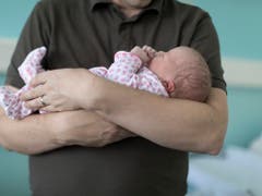Ein Vater mit einem Neugeborenen: der indirekte Gegenvorschlag zur Volksinitiative möchten Vätern immerhin zwei Wochen Vaterschaftsurlaub zugestehen. (Bild: KEYSTONE/GAETAN BALLY)