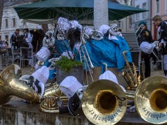 Die Guggenmusik Grachsymphoniker macht eine Pause am Cortege des ersten der «Drey scheenschte Daeaeg» in Basel. Bei diesem Aprilwetter waren Stärkungen gefragt. (Bild: KEYSTONE/GEORGIOS KEFALAS)
