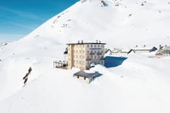 Ungefähr so präsentiert sich das Hotel Furkablick derzeit. Abgesehen von den 8,7 Zentimeter breiten Streifen an den Fensterläden (von Daniel Buren) ist die Kunst noch im Schnee verborgen. (Bild: Christof Hirtler)