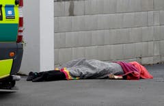 Der Terroranschlag forderte mehrere Tote: Ein lebloser Körper liegt zugedeckt auf dem Gehsteig in Christchurch. (AP Photo/Mark Baker)