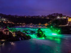 Der Rheinfall in Schaffhausen ist am Samstag zum St. Patricks Day grün beleuchtet worden. (Bild: KEYSTONE/MELANIE DUCHENE)