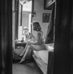 Eine Zirkusartistin des Circus Knie sitzt in ihrem Wohnwagen auf dem Bett und unterhält sich mit einem Clown, aufgenommen in Rapperswil am 17. März 1961. (Bild: Keystone /Str)