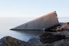 Vom Gebäude ist vom Land aus lediglich der Eingangsbereich sichtbar; das Ganze sieht aus, als wenn ein Tunnelelement oder ein Flugobjekt mit abgerundeten Kanten ins Meer eingetaucht wäre. (Bild: PD/Snöhetta)