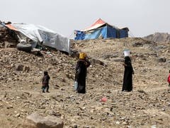 Frauen tragen Wasser in ihr behelfsmässiges Flüchtlingslager im Jemen. (Bild: KEYSTONE/EPA/YAHYA ARHAB)