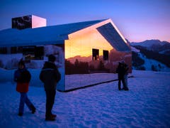 Spaziergänger auf dem Winterwanderweg zwischen Gstaad und Schönried sehen sich die Installation des amerikanischen Küstlers Doug Aitken an. (Bild: KEYSTONE/ANTHONY ANEX)