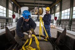 Dennis Eger (links) und Bernhard Arnold beim Befestigen des Kamin-Halters (Bild: Dominik Wunderli, Luzern, 11. April 2019)